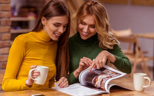 Zwei Frauen schauen einen Katalog an.