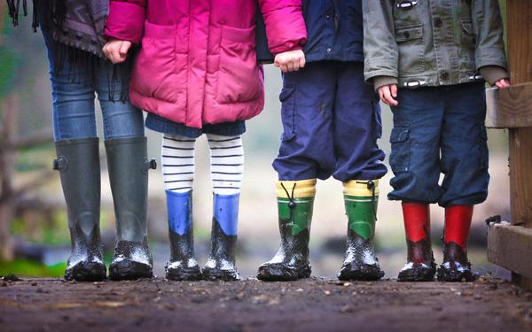 Vier Kinder mit Gummistiefeln